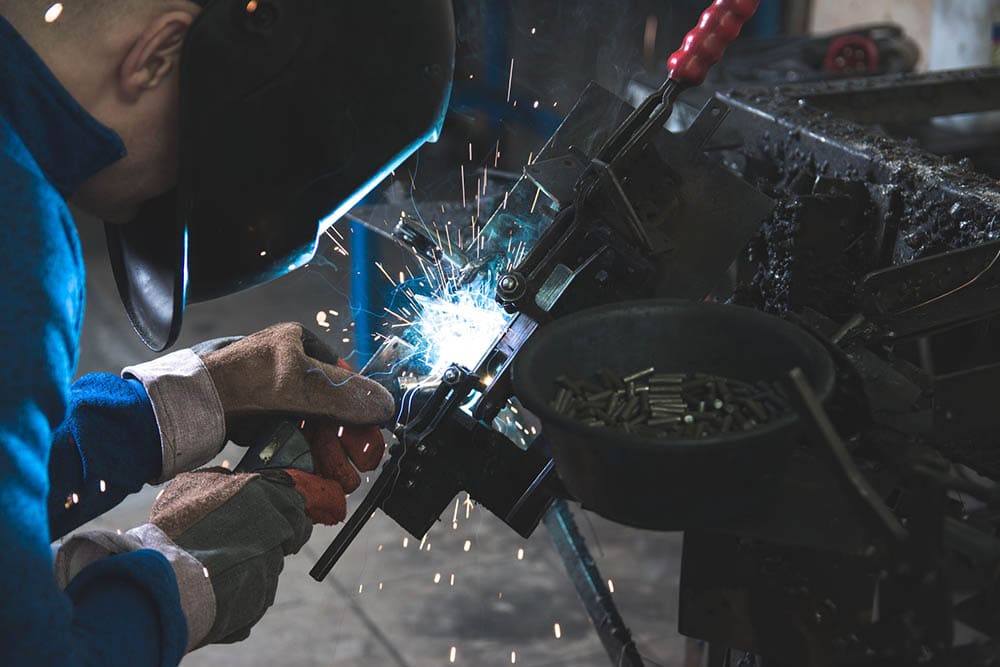 man welding black metal