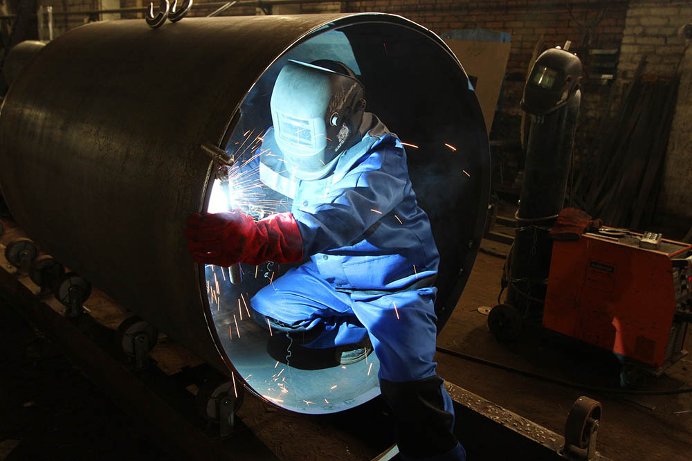 person welding a tube pipe